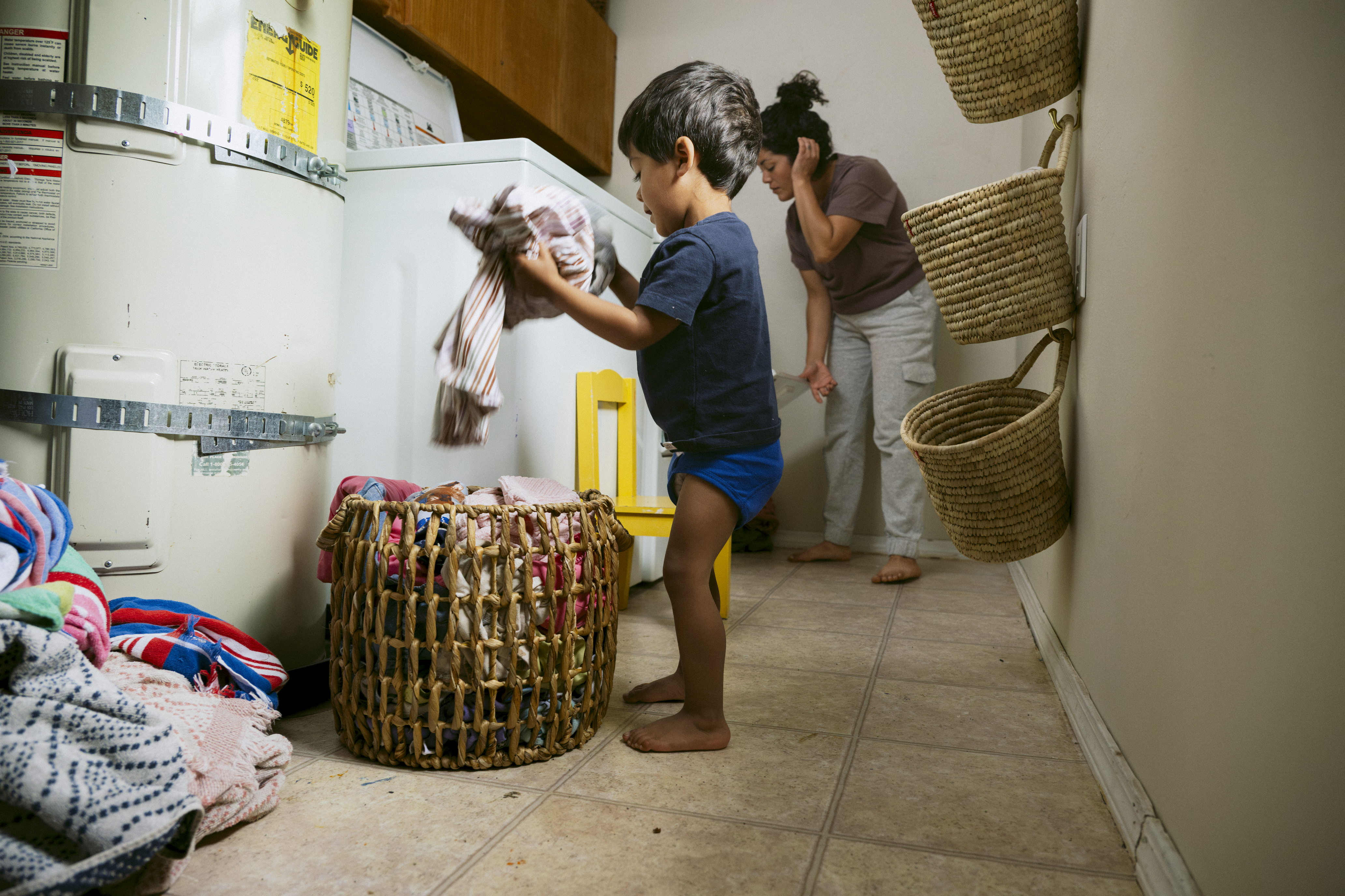 Little boy helping mother do laundry.